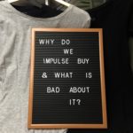 Hanging clothes with a sign saying 'Why do we impulse buy and what is bad about it?'